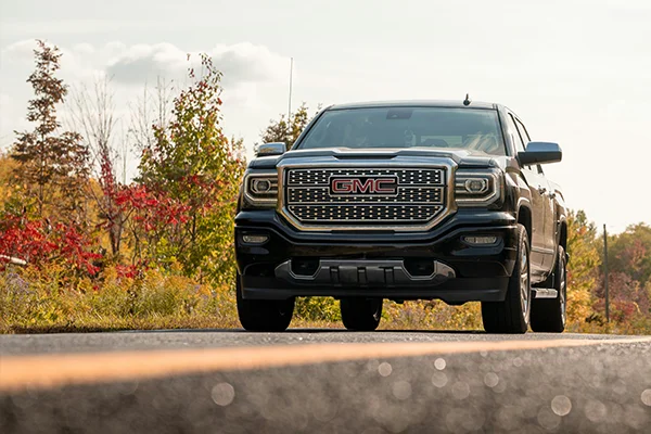 Black GMC pickup truck driving on road