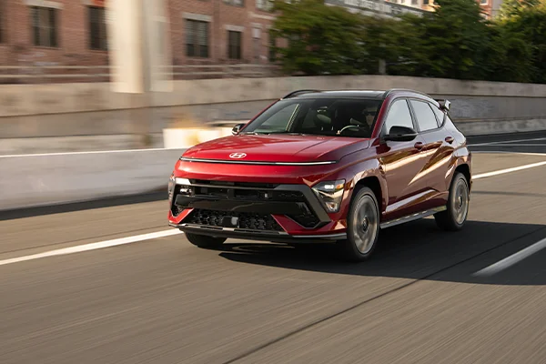 Red Hyundai crossover driving on road