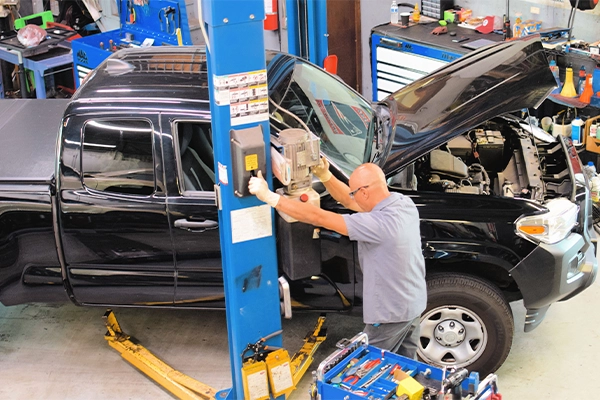 Technician raising truck on lift in Same Day Auto Service shop